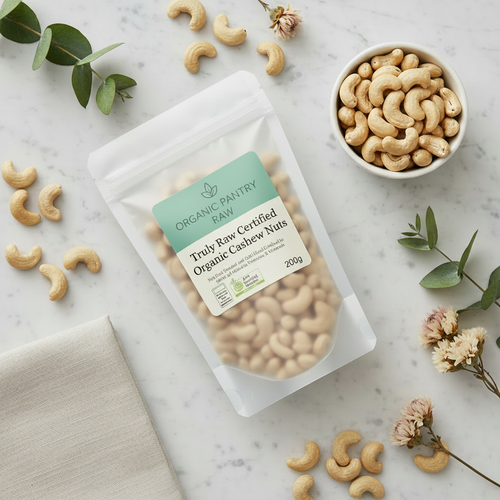 Organic Pantry Raw 200g bag of Truly Raw Cashews on a marble countertop with loose nuts and flowers—perfect for healthy snacking and gourmet recipes.